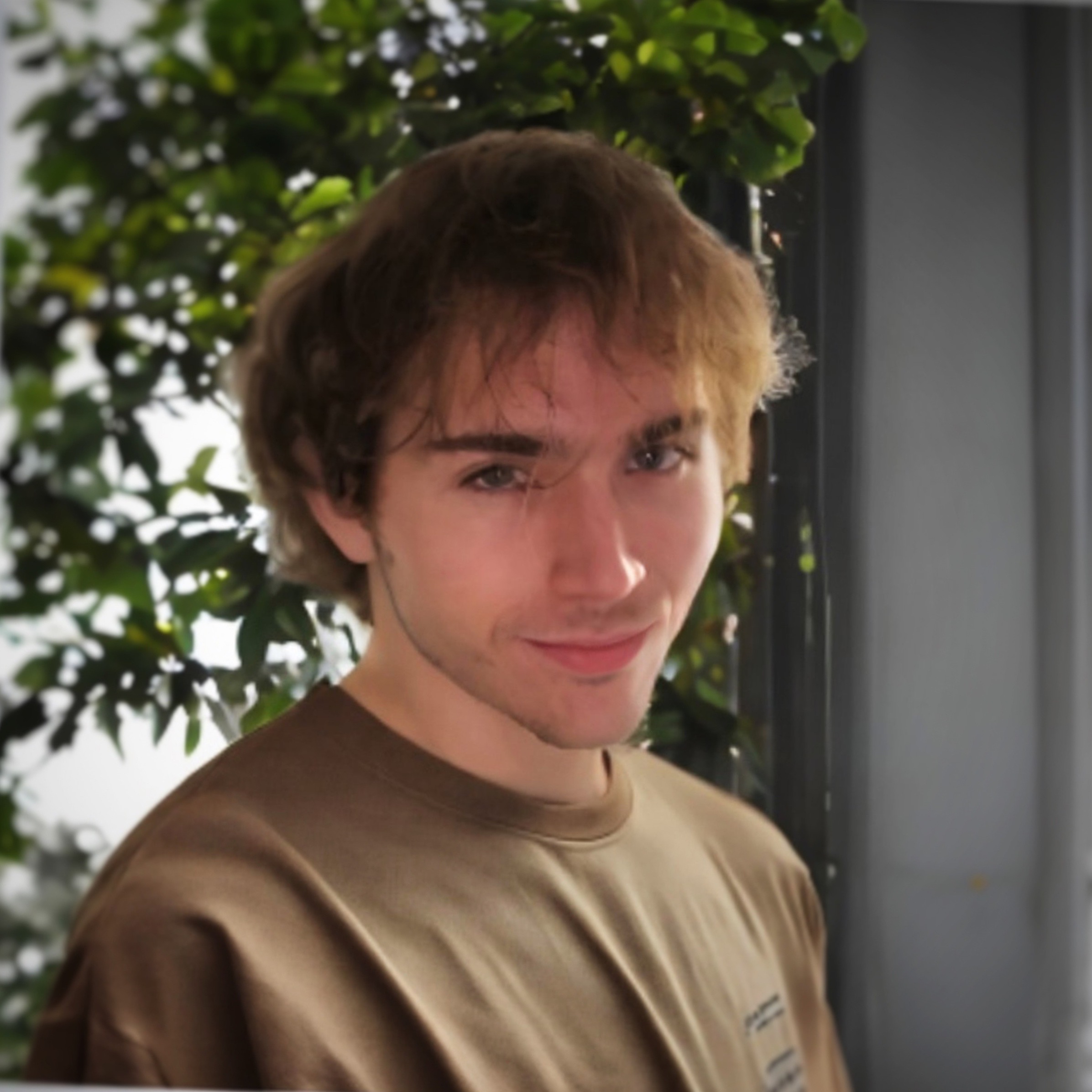 A headshot photo of Logan Jorgensen (me) in a brown shirt