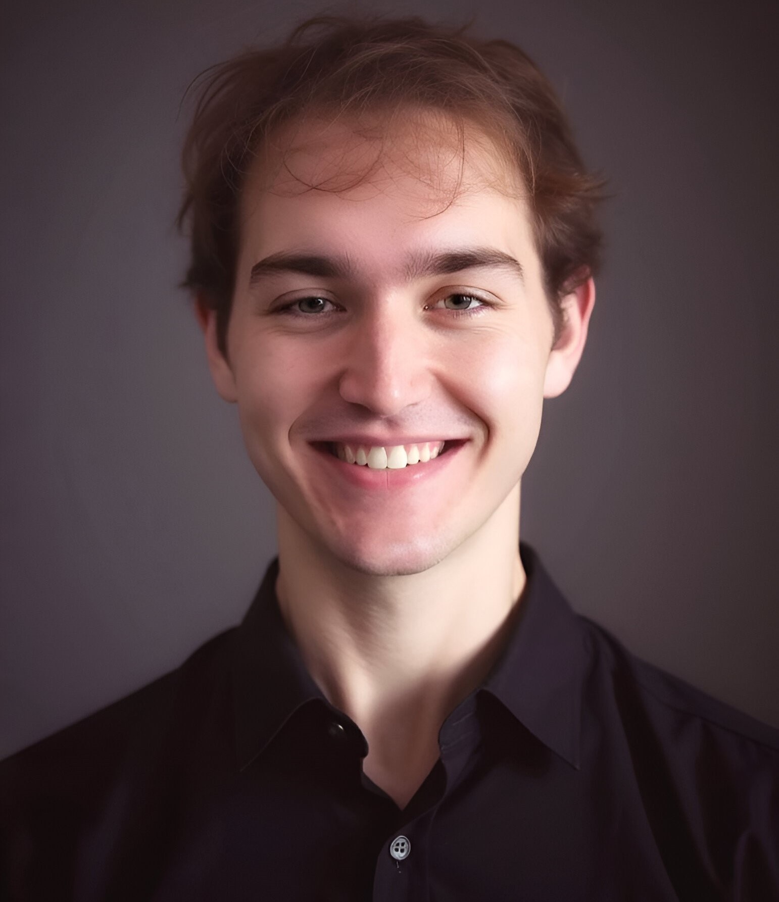 A headshot photo of Logan Jorgensen (me) in a brown shirt